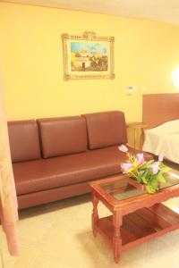 a living room with a brown couch and a coffee table at Hotel Puuc in Oxkutzcab