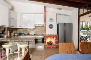 uma cozinha com um fogão e uma lareira em Verdizela Pool & Garden em Charneca