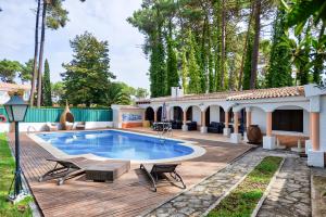 a house with a swimming pool and a wooden deck at Verdizela Pool & Garden in Charneca