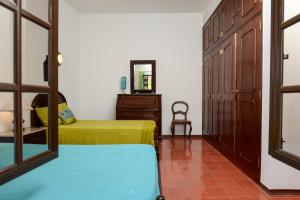 a bedroom with two beds and a dresser and a mirror at Verdizela Pool & Garden in Charneca