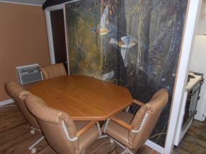 a dining room table with chairs and a painting at Martin's River Cabin in Dresden