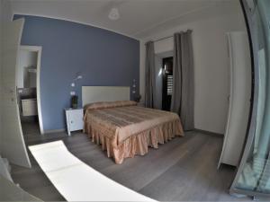- une chambre avec un lit et un miroir dans l'établissement I Vicini della Cattedrale, à Palerme