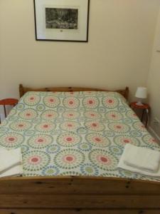 Una cama con edredón en un dormitorio en Dora Apartment Užupis, en Vilna