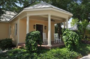 a small yellow house with two chairs on a porch at The Inn at Houmas House Estate in Darrow