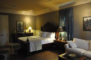 a bedroom with a large bed and a couch at The Inn at Houmas House Estate in Darrow