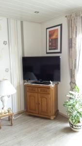 a living room with a large flat screen tv at Ferienwohnung Haus Antje in Norden