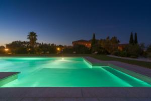 a swimming pool lit up at night at Janas Country Resort in Mores