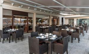 a dining room with tables and chairs and windows at Hotel Lakend in Udaipur