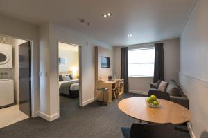 a hotel room with a couch and a table at Quest Dunedin Serviced Apartments in Dunedin