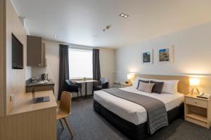 Rúm í herbergi á Quest Dunedin Serviced Apartments