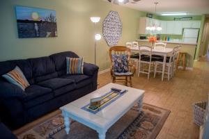 a living room with a couch and a table at Pawley's True Blue in Pawleys Island