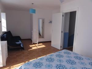 1 dormitorio con cama, silla y espejo en Casa Pelourinho, en Silves