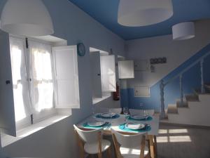 een blauwe kamer met een tafel en stoelen en een trap bij Casa Pelourinho in Silves