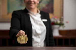 a woman is holding up a gold medal at Hotel Poseidon in Positano +37 photos