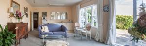 a living room with a blue chair and a table at The Whitehouse of Marybank in Nelson