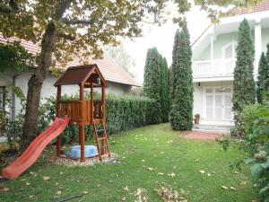 a playground in a yard with a red slide at Csokonai guesthouse in Zamárdi