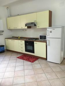 a kitchen with white appliances and a red rug at Res. CENTRO STORICO in Fano