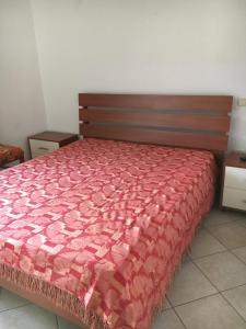 una camera da letto con un letto con un piumone rosso di Res. CENTRO STORICO a Fano