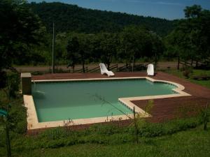 a swimming pool with two chairs sitting around it at Aires del Monte in El Soberbio