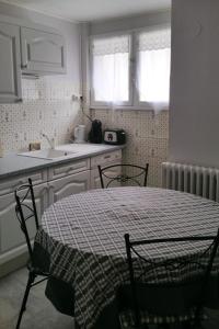 een keuken met een tafel en stoelen en een wastafel bij T2 Bis Luchon in Luchon