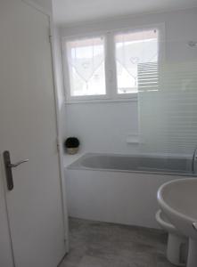Baño blanco con bañera y lavamanos en T2 Bis Luchon, en Luchon