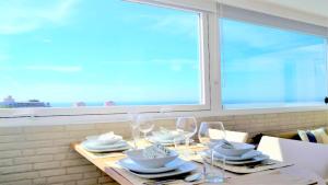 a table with plates and wine glasses and a window at Panorama Penthouse in Espinho +50 photos