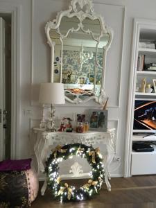 una mesa blanca con espejo y una corona de Navidad en Luxury My home, en Tolentino