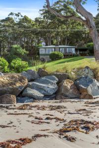 un autobus è parcheggiato davanti ad alcune rocce di Summertime Cottage a Southport