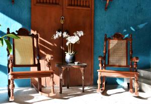 two chairs and a table with a vase of flowers at Hotel Mary Carmen in Cozumel