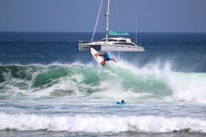 
a man riding a wave on top of a surfboard at Playa Venao Hotel Resort in Playa Venao
