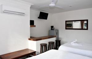 a bedroom with two beds and a table and a mirror at Hotel Mary Carmen in Cozumel