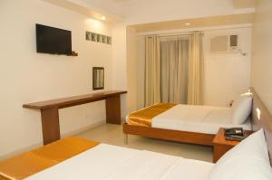Postel nebo postele na pokoji v ubytování M Suites Hotel