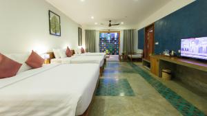 a hotel room with two beds and a flat screen tv at Diamond D'angkor Boutique in Siem Reap