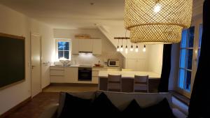 a kitchen with a table and chairs and a chandelier at Le Chanteclair in Gembloux