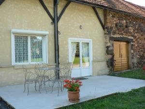 un patio avec des chaises et une table en face d'un bâtiment dans l'établissement Maison region de Domme, à Saint-Martial-de-Nabirat