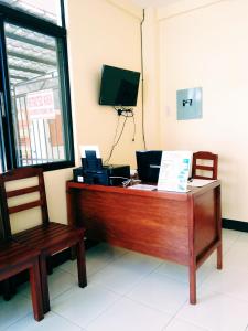 een bureau met een computer en 2 stoelen bij Mariner's Pension House in Puerto Princesa City