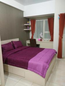 a bedroom with a purple bed and a desk at Wjy Apartment Margonda Residence 5 in Depok