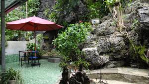 a table and an umbrella next to a stone wall at Huong Thao 2 Hotel in Ha Giang
