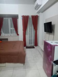 a living room with a couch and red curtains at Wjy Apartment Margonda Residence 5 in Depok