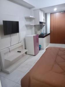 a living room with a tv on a wall at Wjy Apartment Margonda Residence 5 in Depok
