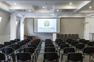 トラスコヴェッツにあるGreen Park Hotel & SPAの椅子とプロジェクションスクリーン付きの部屋