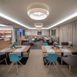 a restaurant with wooden tables and blue chairs at Hotel Frauenschuh Garni in Salzburg