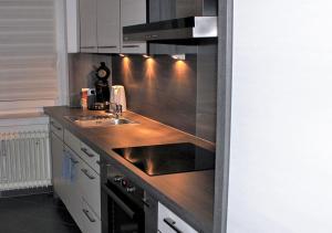 a kitchen with a sink and a stove top oven at Apartment Köln Weiden in Cologne