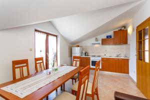 a kitchen with a wooden table and chairs in a room at Apartment Baldigara in Njivice
