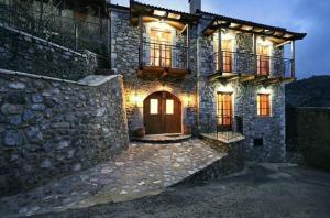 a large stone building with a door and a balcony at Archontiko tis Zois in Stemnitsa