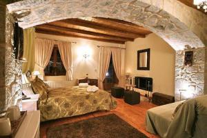 a bedroom with a large bed and a stone wall at Archontiko tis Zois in Stemnitsa