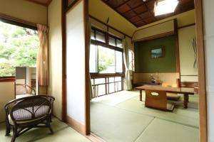 Zimmer mit einem Tisch, einem Stuhl und einem Fenster in der Unterkunft Wakariki Ryokan in Yanagawa