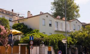 a white house with a fence and street signs at Hotel Tritone in Trieste