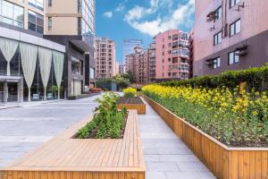 a city street with a row of plants and buildings at Green Court Residence Jinqiao Diamond Shanghai in Shanghai