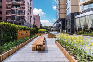 a row of benches in a city with buildings at Green Court Residence Jinqiao Diamond Shanghai in Shanghai